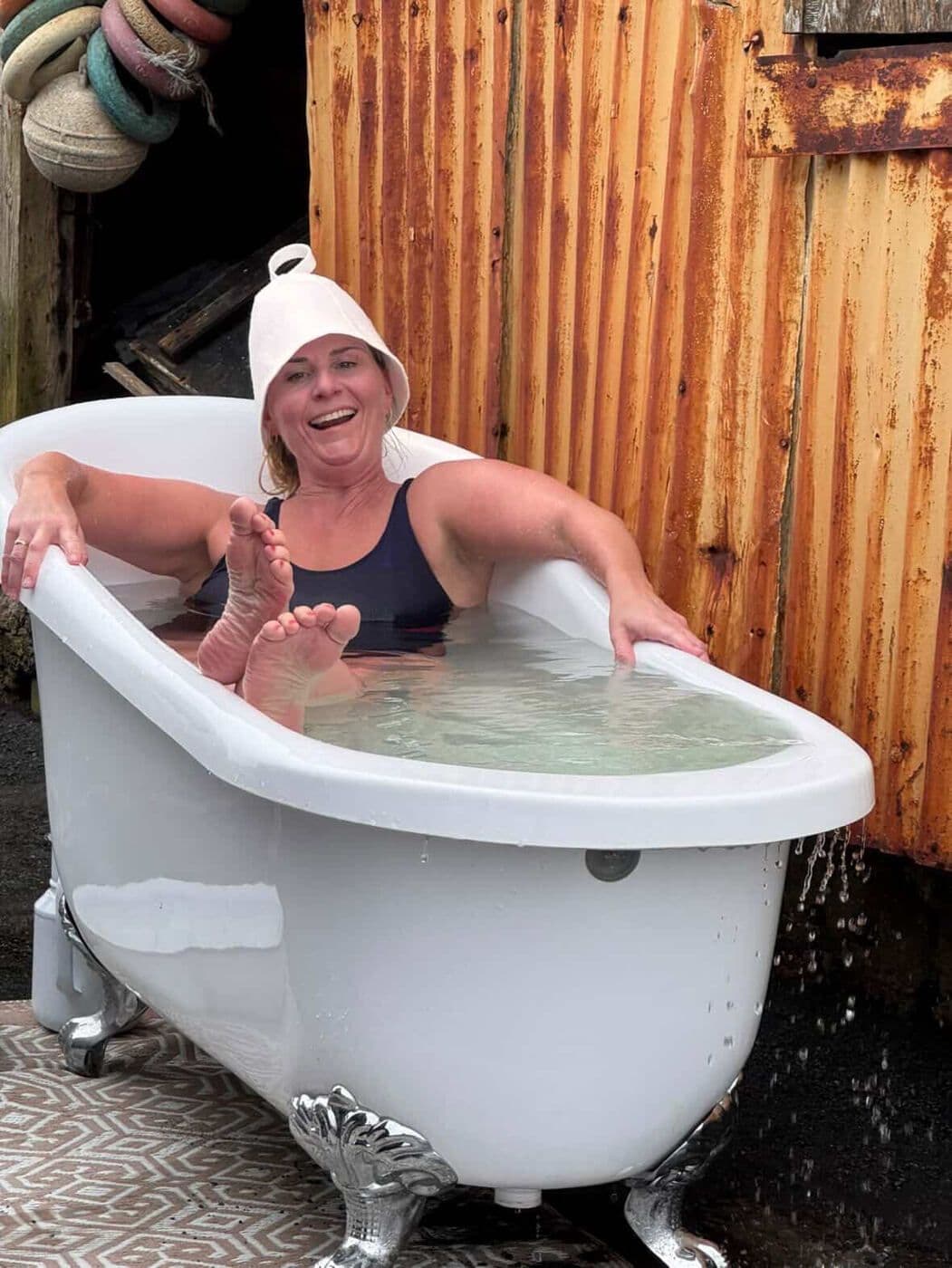 Hlæjandi gestur með saunahatt í köldu baði